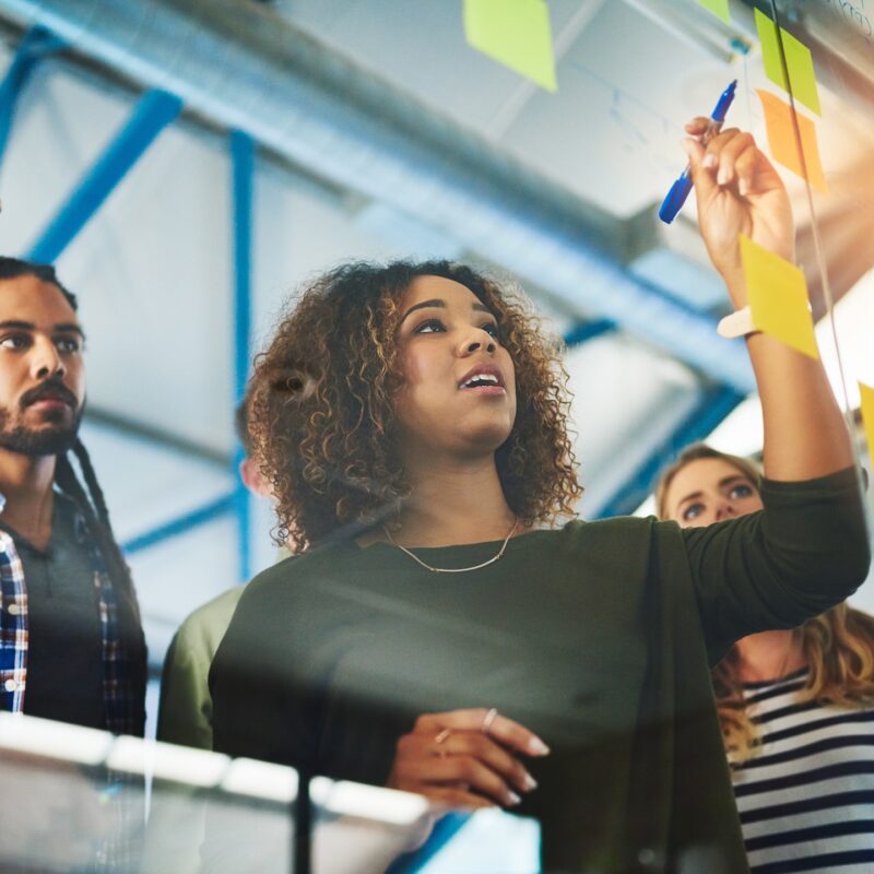 Sharing experience and expertise for an excellent brainstorming session. Shot of colleagues having a brainstorming session with sticky notes at work. content-image